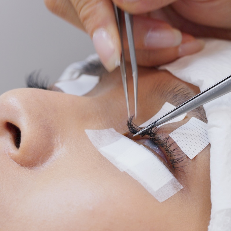 Beautician and young woman in a beauty salon with eye lash extension Beautician and young woman in a beauty salon with eye lash extension