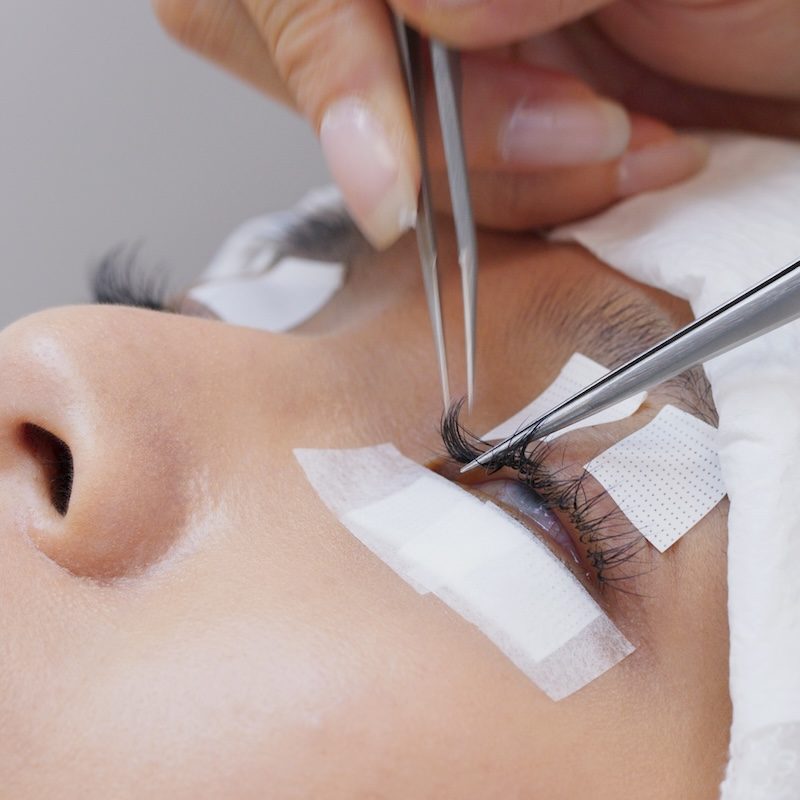 Beautician and young woman in a beauty salon with eye lash extension Beautician and young woman in a beauty salon with eye lash extension